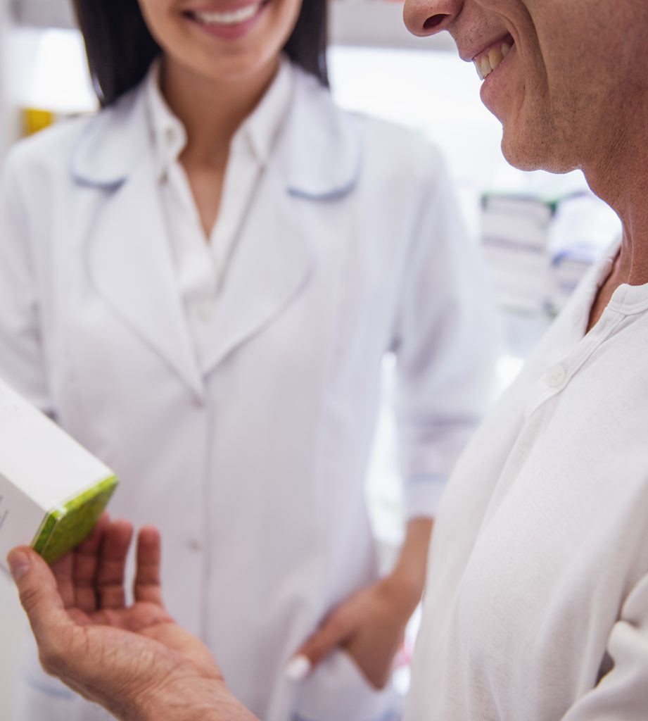 Beautiful young female pharmacist is suggesting a medication to a client at the pharmacy and smiling